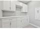 Laundry room with modern white cabinets and quartz countertop and an electric wall-mounted heater at 5670 Shorebird Br, Land O Lakes, FL 34638