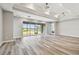 Bright living room featuring large windows with lake views, tray ceilings, and wood flooring at 5670 Shorebird Br, Land O Lakes, FL 34638