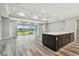 Spacious living room features wood-look floors, large windows with pond views, and a stylish center island with seating at 5670 Shorebird Br, Land O Lakes, FL 34638