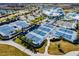 Overhead view of multiple tennis courts in a well-maintained community with lush landscaping and nearby amenities at 5670 Shorebird Br, Land O Lakes, FL 34638