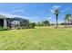 Sprawling backyard featuring a screened-in enclosure, palm trees, and ample green space at 5828 Clairwood Ct, Palmetto, FL 34221