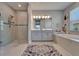 Bathroom featuring a dual sink vanity, bathtub and a glass shower with tile surround at 5828 Clairwood Ct, Palmetto, FL 34221
