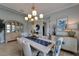 Bright dining area featuring a stylish chandelier, coastal-themed decor, and modern furnishings at 5828 Clairwood Ct, Palmetto, FL 34221