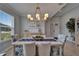 Elegant dining room with a stylish chandelier, seating for six, and bright natural light from a large window at 5828 Clairwood Ct, Palmetto, FL 34221