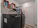 Laundry room with black, front-load washer and dryer, complemented by wire shelving and storage at 5828 Clairwood Ct, Palmetto, FL 34221
