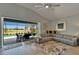 Well-lit living room with tile flooring, comfortable seating, and views of the pool area at 5828 Clairwood Ct, Palmetto, FL 34221