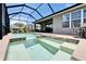 Screened in pool and spa area with brick trim and outdoor furniture seating area at 5828 Clairwood Ct, Palmetto, FL 34221