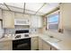 Updated kitchen featuring white cabinets, a stove, and a window above the sink at 5925 Shore S Blvd # 602, Gulfport, FL 33707