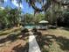 Backyard pool with lush greenery, mature trees, and patio furniture, perfect for relaxation and outdoor entertaining at 611 Bannockburn Ave, Temple Terrace, FL 33617