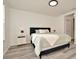 Well-lit bedroom featuring a black bed frame, neutral bedding, and modern nightstands at 6233 Olivedale Dr, Riverview, FL 33578