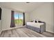 Bedroom featuring a gray daybed, gray wood-look floors, neutral walls, and a large bright window at 6233 Olivedale Dr, Riverview, FL 33578