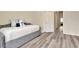 Bedroom featuring a gray daybed, gray wood-look floors, neutral walls, and access to closet and hallway at 6233 Olivedale Dr, Riverview, FL 33578