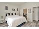 Bedroom with a queen-sized blue bed, gray wood-look floors, and an open door to an office at 6233 Olivedale Dr, Riverview, FL 33578