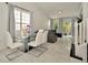 Dining room with a modern glass table, white chairs, and bright natural lighting at 6233 Olivedale Dr, Riverview, FL 33578