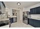Modern kitchen with stainless steel appliances and dark blue cabinets, showcasing an open-concept design at 6233 Olivedale Dr, Riverview, FL 33578