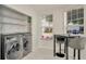 Well-lit laundry room featuring modern washer and dryer with shelving for optimal storage solutions at 6233 Olivedale Dr, Riverview, FL 33578
