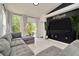 Bright living room with large windows, gray sectional sofa, and modern black accent wall at 6233 Olivedale Dr, Riverview, FL 33578