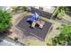 Aerial view of a fenced in playground with play structure and wood chip ground cover at 6233 Olivedale Dr, Riverview, FL 33578
