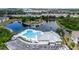Aerial view of community pool, parking lot and nearby pond surrounded by trees and landscaping at 6233 Olivedale Dr, Riverview, FL 33578