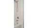 Close up of shower with white tile, adjustable shower head, and new faucet at 6233 Olivedale Dr, Riverview, FL 33578