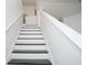 Clean staircase with white walls and black steps, offering a stylish transition between levels in the home at 6233 Olivedale Dr, Riverview, FL 33578