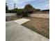 Large backyard area showcasing a stone patio, perimeter wall and landscaping at 627 E Davis Blvd, Tampa, FL 33606