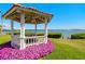 Charming gazebo is surrounded by vibrant flowers, with a picturesque waterfront backdrop at 6295 Bahia Del Mar Cir # 406, St Petersburg, FL 33715