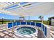 Relaxing hot tub with a pergola overlooking the waterfront, providing a luxurious outdoor experience at 6295 Bahia Del Mar Cir # 406, St Petersburg, FL 33715