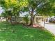 Well-maintained front yard with lush lawn, trees, and a view of the house with a carport at 6415 13Th N Ave, St Petersburg, FL 33710