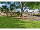 Charming home with well-manicured lawn, mature trees, and inviting carport, nestled in a serene neighborhood at 6415 13Th N Ave, St Petersburg, FL 33710