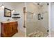 Bathroom vanity and shower featuring neutral tile, dark framed mirror, and brushed nickel fixtures at 6442 Lake Sunrise Dr, Apollo Beach, FL 33572