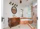 Bathroom featuring a marble-trimmed tub and glass shower with wood-look flooring at 6442 Lake Sunrise Dr, Apollo Beach, FL 33572