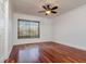 Bedroom featuring hardwood floors, white walls, a ceiling fan, and a window with wooden blinds at 6442 Lake Sunrise Dr, Apollo Beach, FL 33572