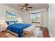 This bedroom features a ceiling fan, hardwood floors, white walls, and a window with wooden blinds at 6442 Lake Sunrise Dr, Apollo Beach, FL 33572
