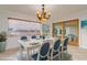 Staged dining room with elegant chandelier, coastal decor, and natural light from a large window at 6442 Lake Sunrise Dr, Apollo Beach, FL 33572