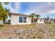 White stucco home with tropical palm trees in the front yard creating a relaxed coastal aesthetic at 6442 Lake Sunrise Dr, Apollo Beach, FL 33572