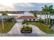 Charming waterfront home boasts lush landscaping and a circular driveway, providing stunning curb appeal at 6442 Lake Sunrise Dr, Apollo Beach, FL 33572