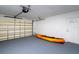 Garage featuring a closed garage door, an orange kayak, and a door leading to the outside at 6442 Lake Sunrise Dr, Apollo Beach, FL 33572