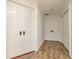 Hallway featuring wood-look flooring, white doors, and an open layout at 6442 Lake Sunrise Dr, Apollo Beach, FL 33572