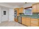 Kitchen features stainless steel appliances and light wood cabinets with a tiled backsplash at 6442 Lake Sunrise Dr, Apollo Beach, FL 33572
