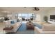 Bright, staged living room with wide water views, contemporary furniture, and neutral flooring at 6442 Lake Sunrise Dr, Apollo Beach, FL 33572