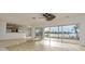Bright open living room with tile floors, ceiling fan, and sliding glass doors to the water view at 6442 Lake Sunrise Dr, Apollo Beach, FL 33572