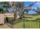 View of backyard featuring a serene pond, lush trees, and community buildings at 6842 Dartmouth Hill St, Riverview, FL 33578