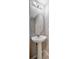 Elegant pedestal sink bathroom featuring a modern mirror and fixtures, complemented by neutral wall tones and clean lines at 6842 Dartmouth Hill St, Riverview, FL 33578