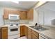 Bright kitchen featuring light wood cabinets, white appliances, and ample counter space, ideal for cooking and entertaining at 6842 Dartmouth Hill St, Riverview, FL 33578