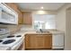Well-lit kitchen with light wood cabinets, white appliances, and a pass-through window to the dining area at 6842 Dartmouth Hill St, Riverview, FL 33578