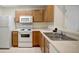 Modern kitchen featuring light wood cabinets, white appliances, and a sleek design, providing a functional and stylish cooking space at 6842 Dartmouth Hill St, Riverview, FL 33578