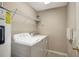 Functional laundry room with a washer, dryer, overhead shelving, and hot water heater at 6842 Dartmouth Hill St, Riverview, FL 33578