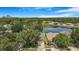 Aerial view of homes with manicured lawns and a serene pond in a lush, green neighborhood at 7031 Kendall Heath Way, Land O Lakes, FL 34637