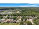 Aerial view of a planned residential community with a lake and green forested area at 7031 Kendall Heath Way, Land O Lakes, FL 34637